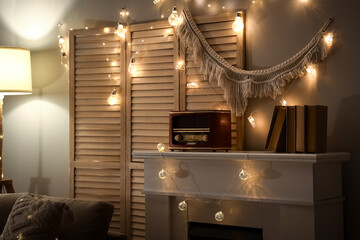 Obraz premium Interior of dark living room with fireplace, folding screen and glowing lights