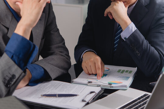 Stressed businessmen analyzing financial crisis charts at office desk reviewing bad corporate report managing investment loss risk for bankruptcy economic recession marketing editorial