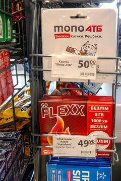 Kyiv, Ukraine, June 1, 2026:  Shelf in a supermarket offering various mobile operator starter packs and a mono atb bank rewards card.