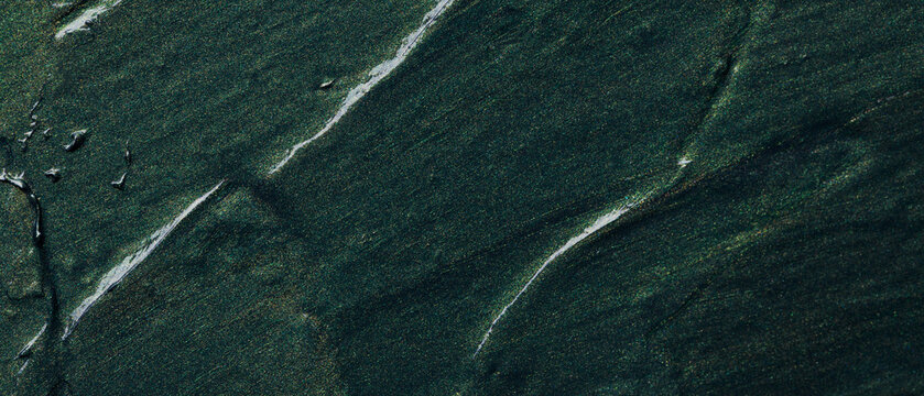 Abstract dark green flowing paint texture with organic brush strokes and movement