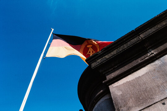 Historisches Foto einer DDR Fahne vor blauen Himmel, vermutlich Berlin, 1990, Deutschland