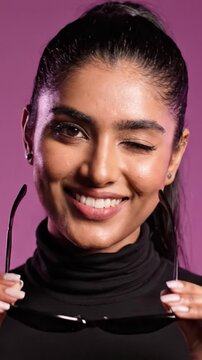 A Stylish Model Showcases Trendy Sunglasses Against a Vibrant Purple Background, Blending Elegance and Contemporary Fashion with a Charismatic Smile