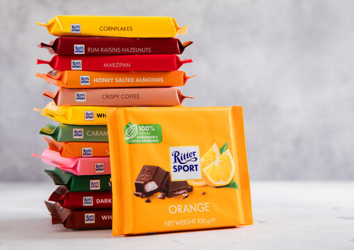 LONDON, UK - MARCH 24, 2026: Ritter Sport chocolate bar with orange fruit yogurt with stack of assorted bars on light table background.