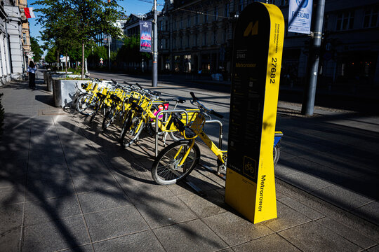 Yellow bike Metropolitan Transport Authority sharing station with row of rental bicycles on a sunny street in Katowice, Poland