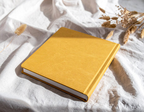 Open Yellow Textured Notebook on Linen Fabric with Dried Flowers and Copy Space