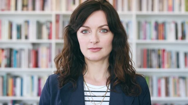 Professional, face and business woman in library for publishing agency, author representative and creative. Literary agent, book editor and confidence with person in startup for pride and bookshelf