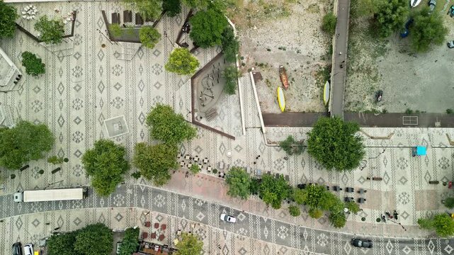 Albania, Shiroka 03 09 2025: Still top down aerial drone video showing cars driving and people walking along Shiroka promenade with traditional patterned pavement beside Lake Shkodra.