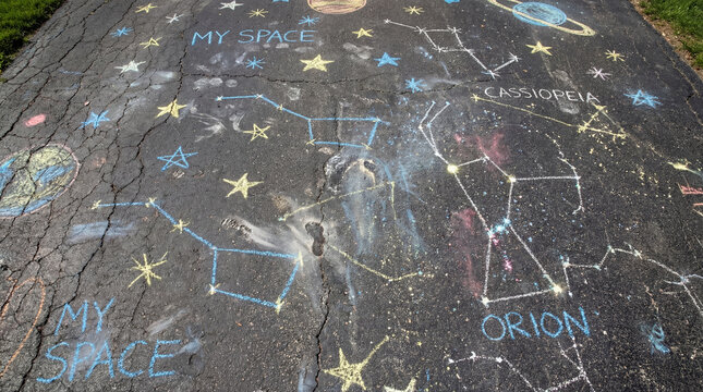 Colorful chalk drawings of planets constellations stars on asphalt showing childrens space learning outdoor creativity astronomy play education astronomy workshop science fair kids outdoor