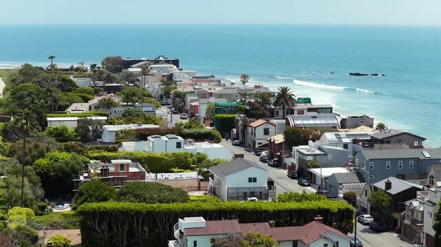 Malibu beachfront real estate with luxurious oceanfront homes and modern mansions next to calm Pacific Ocean shore during sunny day in southern California