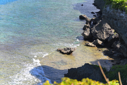 沖縄旅行や自然の造形美を連想させる澄んだエメラルドグリーンの磯辺