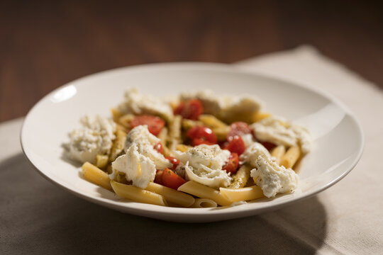 Penne pasta with mozzarella, pesto and fresh cherry tomatoes