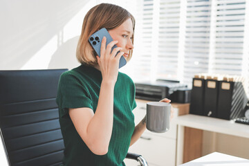 Fototapeta premium Happy female entrepreneur using smart phone in office.