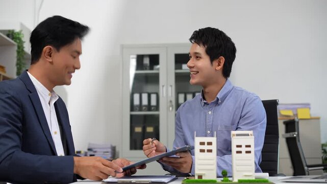 House model with agent asking costumer for contract to buy, get insurance or loan real estate or property.