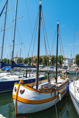 Obraz premium Sailboats docked at a marina under clear blue skies on a sunny day