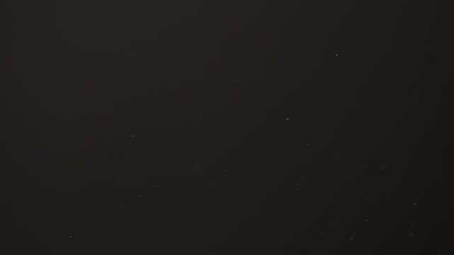 Slow motion real dust flow over dark background