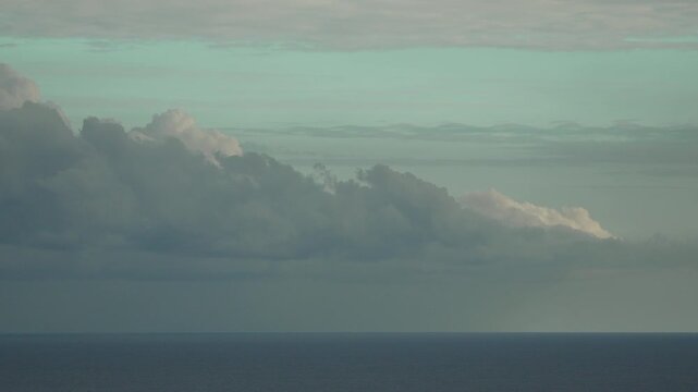 Clouds ocean seascape Dramatic towering thunderclouds drift slowly above the calm blue horizon of the open sea.