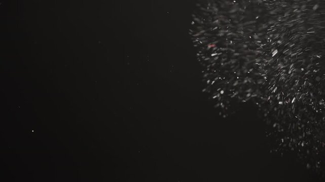 Slow motion real dust flow over dark background