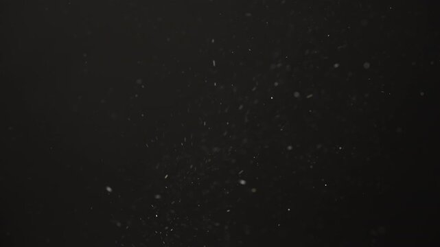 Slow motion real dust flow over dark background