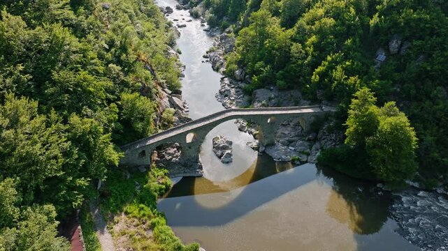 Ancient devils bridge over Arda river rocky canyon forest mountain valley landscape historical stone arch architecture aerial drone view summer travel Bulgaria