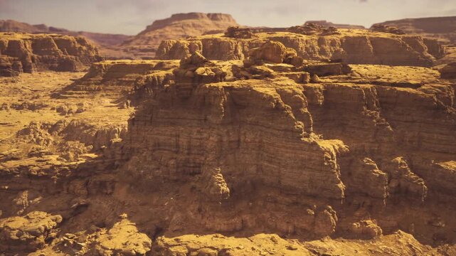 Dramatic eroded canyon wall deep strata warm golden light pronounced shadows rugged ledges weathered sediment geological detail high contrast editorial stock