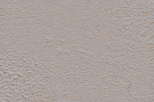 Textured light pink surface with a subtle pattern.