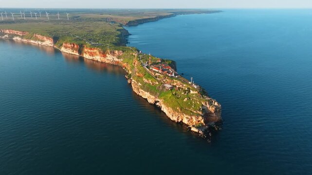 Cape Kaliakra rocky cliff peninsula extending into deep blue sea water surface sunset warm light historical fortress ruins aerial view travel landmarks Bulgaria
