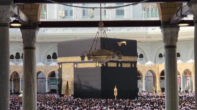 A magnificent panoramic view of the Kaaba with the towering Makkah Royal Clock Tower in the background, surrounded by thousands of Umrah pilgrims during the holy month of Ramadan in Mecca, Saudi Arabi