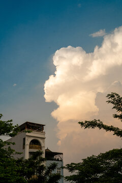 A beautiful cloud formation against a blue sky near a building.