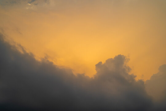 Dramatic sunset with vibrant orange hues and dark storm clouds in the sky.