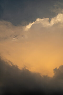 Dramatic sunset clouds painted in warm hues of orange and subdued gray tones.