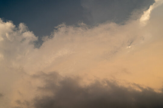 Dramatic sky with soft clouds transitioning from dark to light hues at sunset.