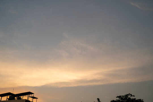 Dusk sky with soft hues and silhouetted rooftops.