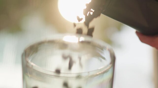The process of making fresh coffee begins with pouring the fragrant, freshly roasted coffee beans from the bag into the coffee grinder on the morning of opening the coffee shop.