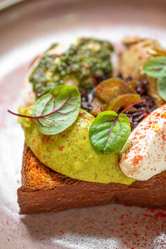 Crispy toast topped with poached eggs creamy sauce and fresh herbs served as elegant brunch dish