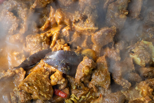 Closeup of steaming spicy mutton curry cooked with aromatic spices