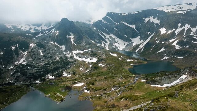 Kidney and  Eye glacial lakes part of Seven Rila Lakes group mountain valley slopes rocky peak with snow patches summer day aerial view Bulgaria