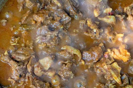 Closeup of a steaming bowl of traditional mutton curry