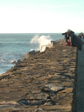 Mujer sacando fotos a las olas del mar