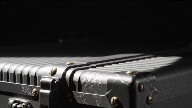 Metal suitcase with scratched surface in dark studio lighting. Close-up of industrial travel case corner hardware. Durable storage equipment for business transport