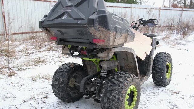 ATV is idling. Four Wheeler Idle Exhaust Fumes. Atvs idling with oversized tires. Power, grip. atv tailpipe blowing vapor underbody muffler surface, exhaust plumes, engine revs creating smoky bursts