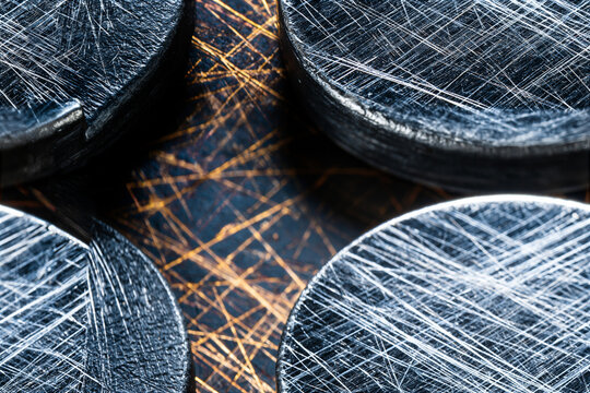Abstract macro photography of circular metallic discs with scratched texture and golden lighting