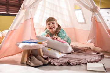Little girl playing in wigwam at home © New Africa