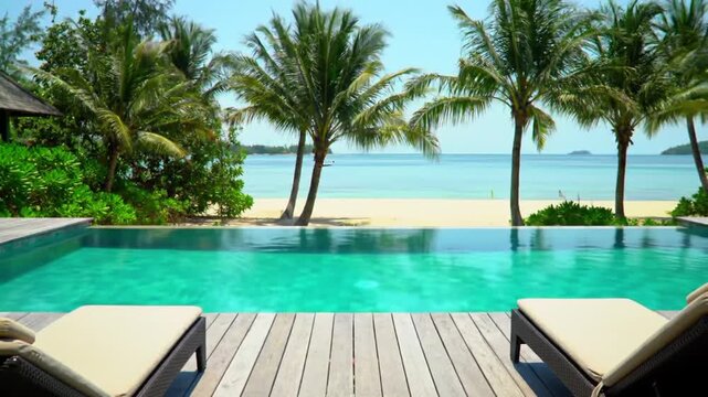 Luxury infinity pool overlooking a tropical beach with palm trees and blue ocean.