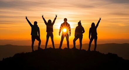 Fototapeta premium Group of people raising arms in celebration at sunset on mountain hilltop