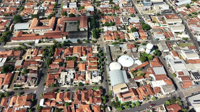 Aerial view of a dense residential neighborhood with terracotta tiled roofs and a central street intersection