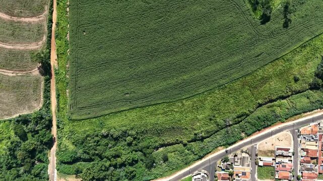 Aerial view of urban sprawl encroaching on agricultural land and lush green vegetation