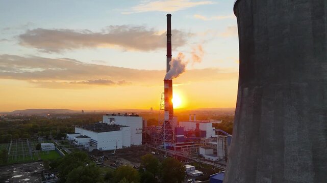 Industrial power plant with smokestack emits steam against sunset backdrop, showcasing gradual light change and landscape details in the foreground and background across three frames