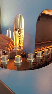 ​Vertical Shot of PET Preforms Moving on Conveyor Chain into Heating Oven