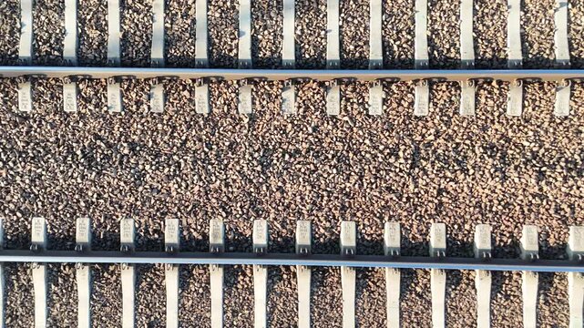 Aerial view of railway tracks showing continuous alignment of metal rails and gravel bed, highlighting the progression of rail infrastructure in a transportation setting
