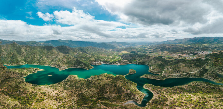 Panoramic aerial view of Siurana Reservoir and surrounding mountains in Catalonia, Spain. Emerald water winding through rugged valleys